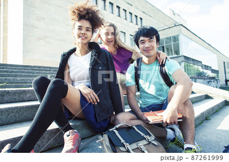 cute group of teenages at the building of university with books huggings, diversity nations, having lunch 87261999