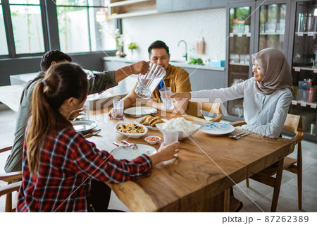 asian young people eating lunch together in the kitchen asian young people eating lunch together in the kitchen 87262389