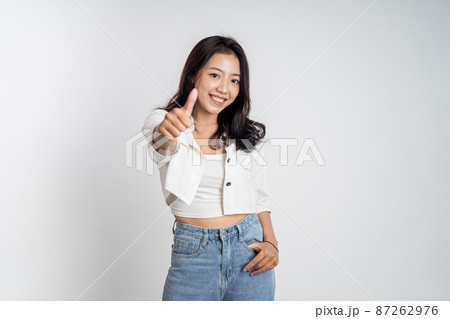 smiling young woman stand with thumbs up on isolated background smiling young woman stand with thumbs up on isolated background 87262976