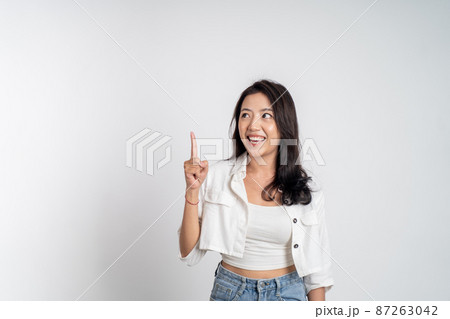 attractive asian woman with finger pointing up hand gesture 87263042