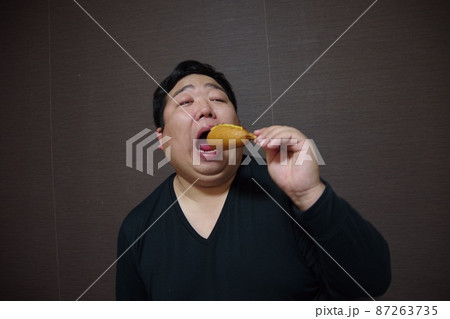 アメリカンドッグを食べている太った人 アメリカンドッグを食べている太った人 87263735