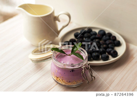 Oat flakes granola or muesli with homemade yogurt smoothie, fresh blueberry and ceramic jug milk 87264396