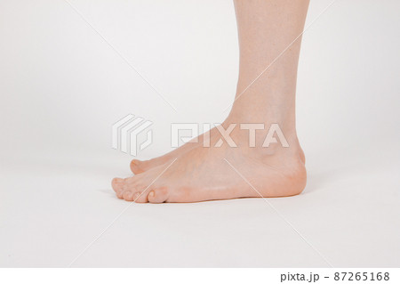 Barefoot and legs isolated on white background. Closeup shot of healthy beautiful female feet. Health and beauty concept. Side view of human foot ream with neutral manicure or pedicure. Sole of foot.