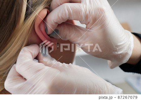 piercings on an ear. Conch and helix piercings close up. piercings on an ear. Conch and helix piercings close up. 87267079