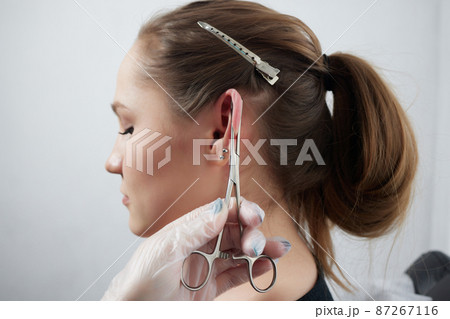 piercings on an ear. Conch and helix piercings close up. piercings on an ear. Conch and helix piercings close up. 87267116