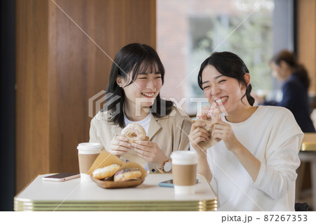 カフェでドーナツを食べる若い女性 カフェでドーナツを食べる若い女性 87267353