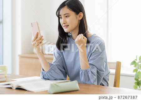 スマホを見ながら勉強をする女の子 高校生 中学生 87267387