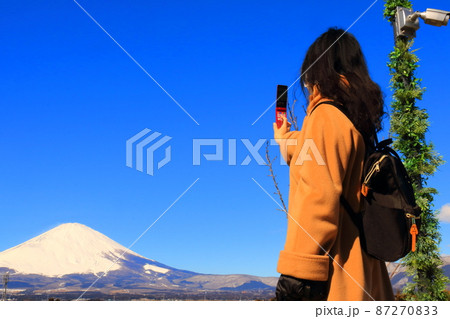 旅先で携帯で写真を撮る女性の姿 87270833