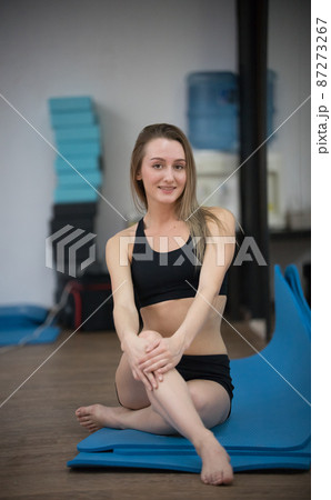 Beautiful young girl posing in yoga class. Healthy lifestyle in fitness club. Stretching 87273267
