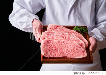 黒毛和牛ロースステーキ肉を手に持つ板前 87274895