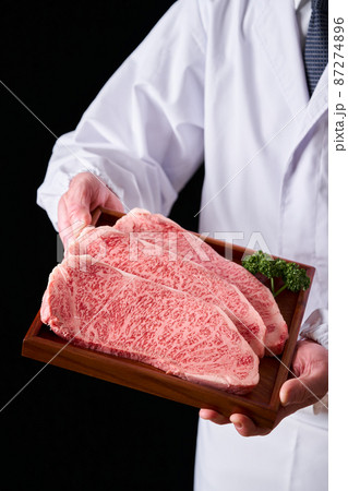 黒毛和牛ロースステーキ肉を手に持つ板前 87274896
