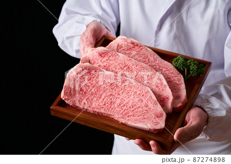 黒毛和牛ロースステーキ肉を手に持つ板前 87274898