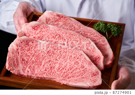 黒毛和牛ロースステーキ肉を手に持つ板前 87274901