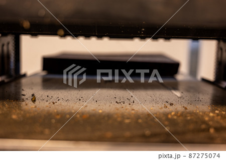 Selective focus looking into a wood planer bed raised above the board 87275074