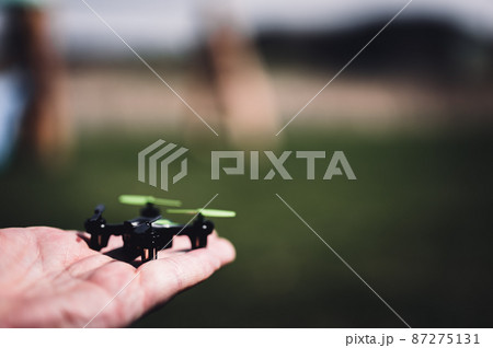Miniature toy remote controlled drone taking off from a hand 87275131