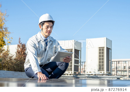 ソーラーパネルをチェックするビジネスマン 87276914