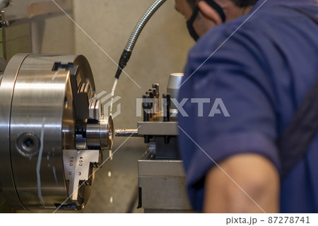 Closeup scene the lathe machine operator working with turning machine. Closeup scene the lathe machine operator working with turning machine. 87278741