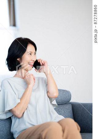 ソファーに座って電話をするシニア女性 87278860