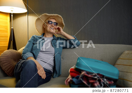 Senior woman with packed luggage for journey 87280771