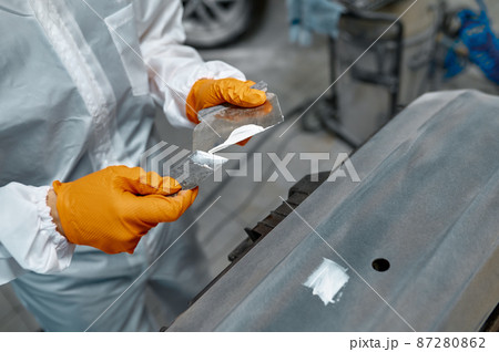 Mechanic engaged in local repairing car body 87280862