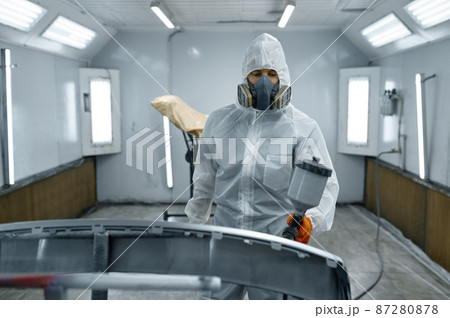 Painter in protective mask painting automobile part 87280878