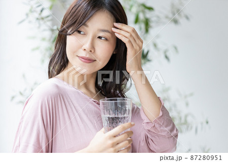 水の入ったグラスを持つ部屋着の女性 水の入ったグラスを持つ部屋着の女性 87280951