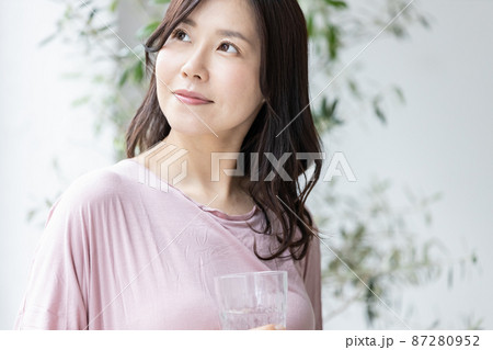 水の入ったグラスを持つ部屋着の女性 水の入ったグラスを持つ部屋着の女性 87280952