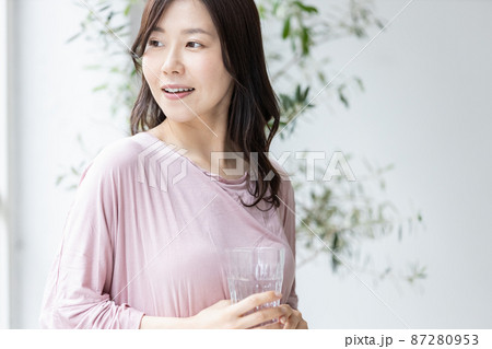 水の入ったグラスを持つ部屋着の女性 水の入ったグラスを持つ部屋着の女性 87280953