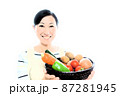 野菜のいっぱい入った籠を持つ女性 87281945
