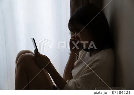 暗い部屋で座る女性 87284521