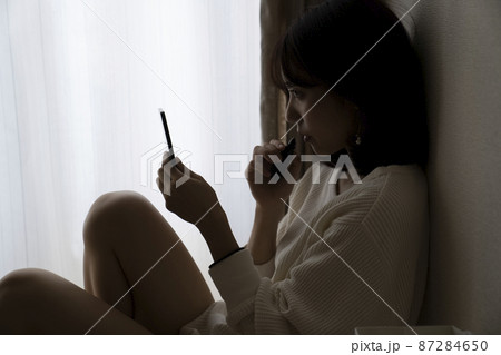 暗い部屋で座る女性 暗い部屋で座る女性 87284650