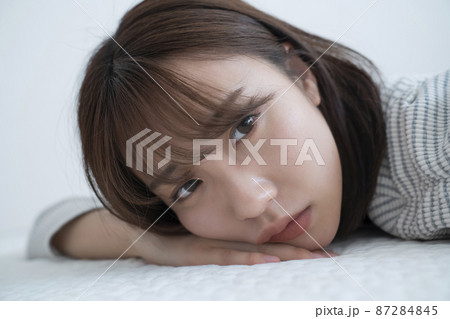部屋で寝そべる女性 87284845