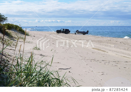 Cars on the beach. Sea sand beach. Calm sea and sandy shore. 87285424