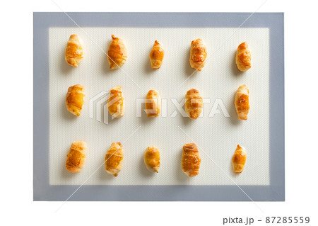 Freshly baked sweet dessert homemade pastries - bagels on a baking mat, top view isolated on white Freshly baked sweet dessert homemade pastries - bagels on a baking mat, top view isolated on white 87285559