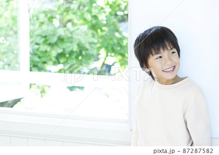 窓辺に立つ笑顔の男の子 窓辺に立つ笑顔の男の子 87287582
