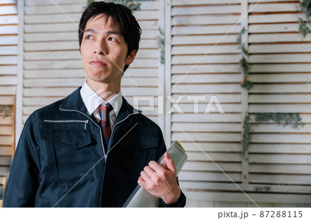書類を持つ作業着を着た男 87288115