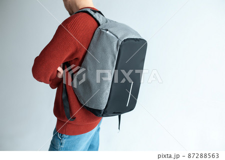 stylish hipster male holding modern backpack bag on white background stylish hipster male holding modern backpack bag on white background 87288563