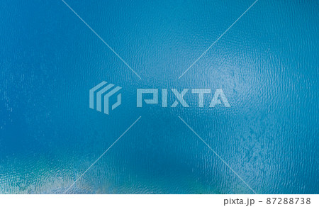 Aerial view of a blue sea surface water texture background and sun reflections Aerial flying drone view Waves water surface texture on sunny tropical ocean in Phuket island Thailand Aerial view of a blue sea surface water texture background and sun reflections Aerial flying drone view Waves water surface texture on sunny tropical ocean in Phuket island Thailand 87288738
