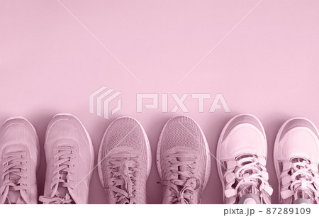 Three pair of sport shoes top view on pink background 87289109