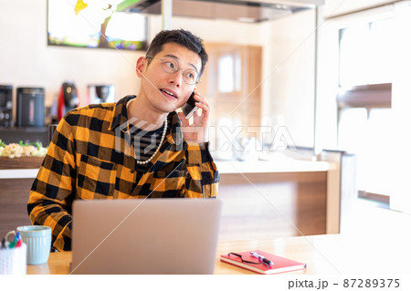 仕事中にクライアントからの電話対応をする男性起業家 仕事中にクライアントからの電話対応をする男性起業家 87289375