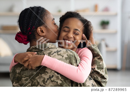Loving black mother in military uniform kissing daughter Loving black mother in military uniform kissing daughter 87289965