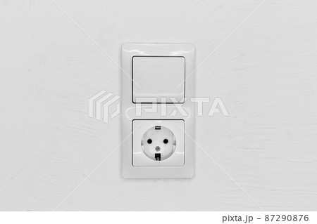 Socket and light off turn on button on the background of the switch white wall of the house, close up Socket and light off turn on button on the background of the switch white wall of the house, close up 87290876