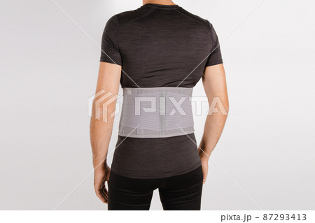 Lumbar brace on the human body isolated on a white background. Trauma of back. Back brace, orthopedic lumbar, support belt for back muscles. Lower back problems health. 87293413