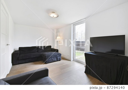 Minimalist living room with black sofa and TV Minimalist living room with black sofa and TV 87294140