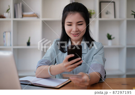 Woman enjoy with online shopping application and typing credit card for fill number to payment with virtual digital asset and metaverse. Woman enjoy with online shopping application and typing credit card for fill number to payment with virtual digital asset and metaverse. 87297195
