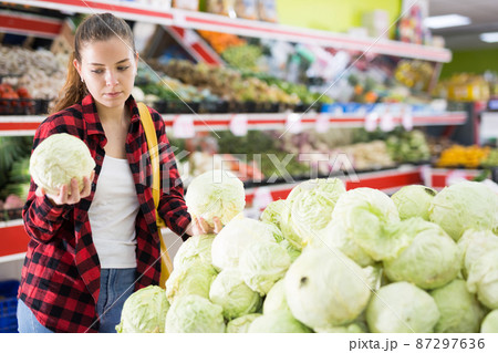 Positive customer chooses cabbages at grocery store Positive customer chooses cabbages at grocery store 87297636