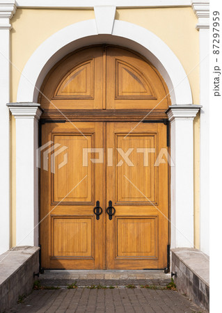 Old wooden door in yellow wall, background texture Old wooden door in yellow wall, background texture 87297959