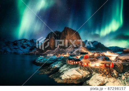 Aurora borealis, Northern lights over mountain with fishing village on coastline at Hamnoy, Lofoten islands 87298157