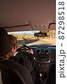 unrecognizable blonde woman driving a car on the road 87298518
