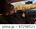 unrecognizable blonde woman driving a car on the road 87298521
